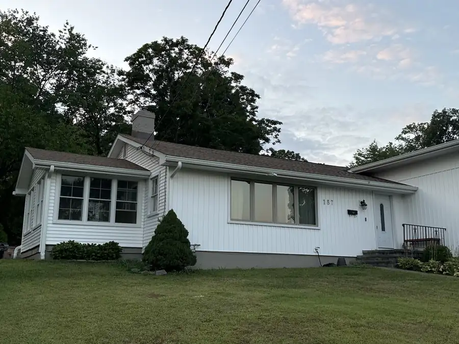 Finished white ranch house from the front lawn