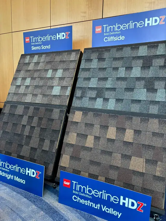 Display boards of asphalt shingle samples, including GAF Timberline HDZ, set out as supplier product samples